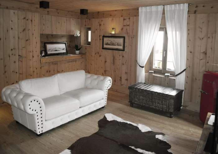 Anteroom suite with white leather sofa bed and pine wood furnishings